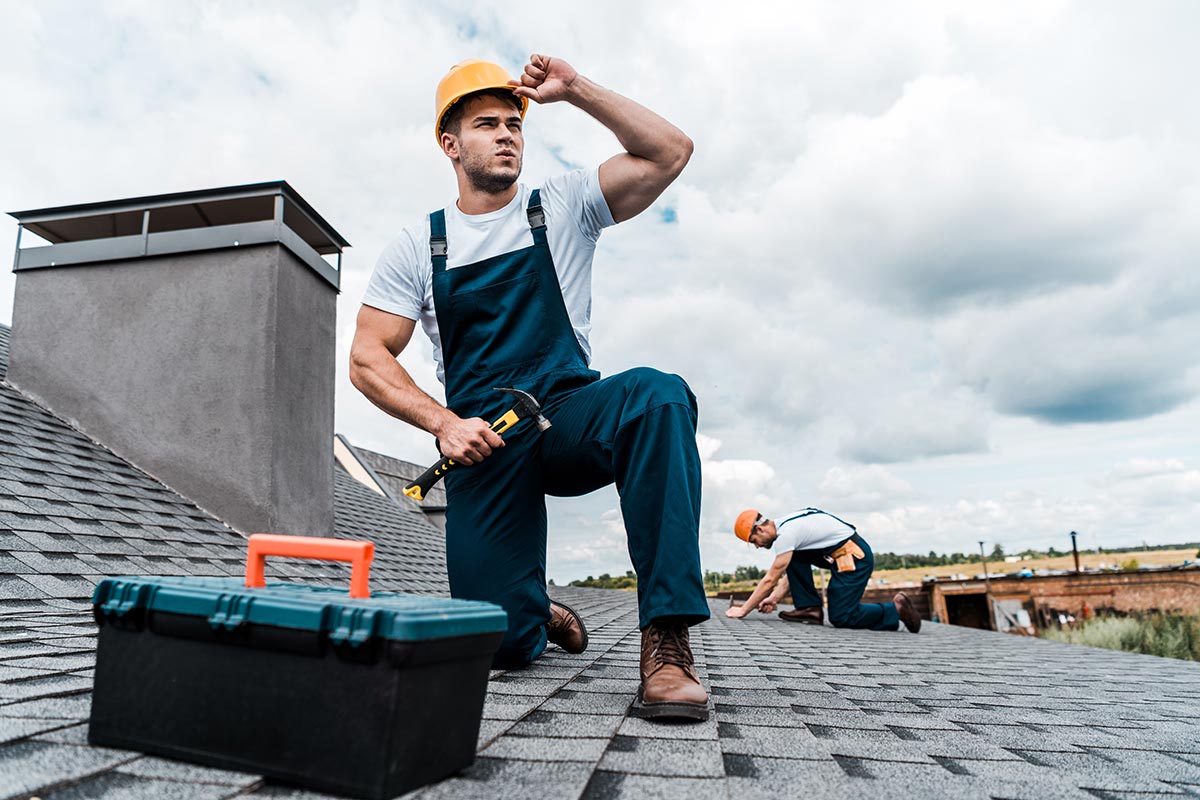 A handyman performs a rooftop chimney inspection, ensuring structural safety and integrity.